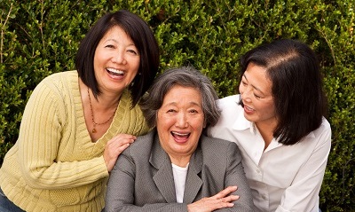 A mother and two daughters laughing.