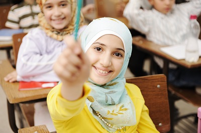 Girl in classroom raising her hand
