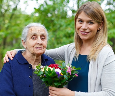 Older woman and younger woman posing with flowers