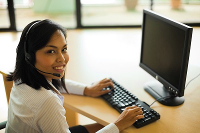 woman wearing headset at a computer