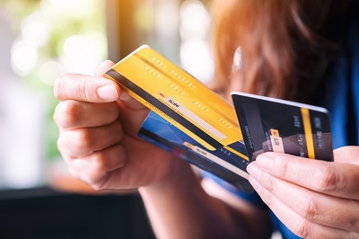 woman holding three credit cards