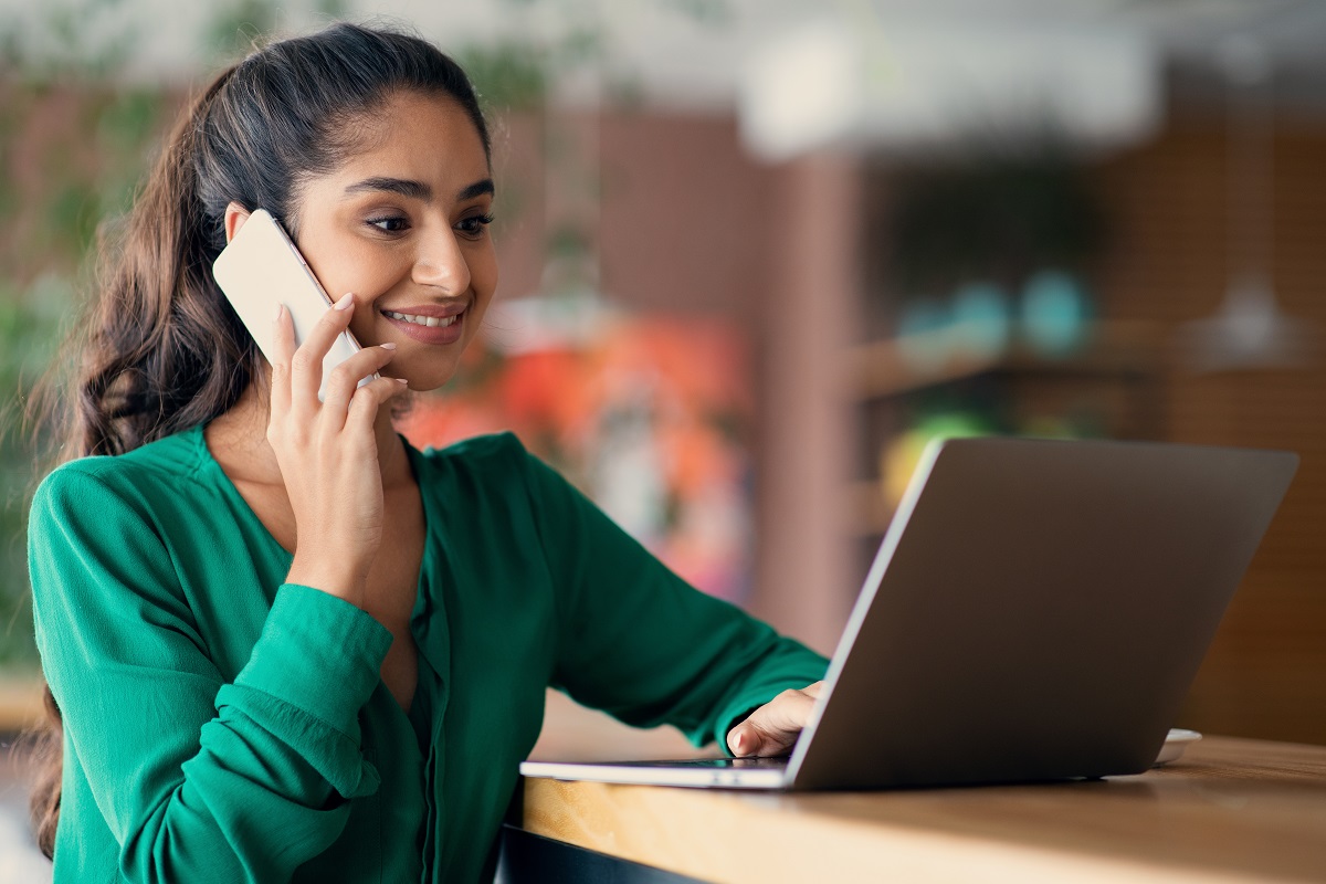 Woman of Indian descent on the phone and laptop