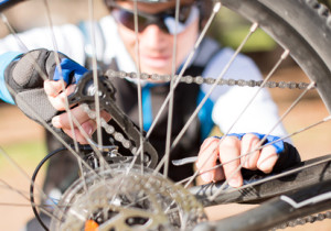 Man wearing sunglasses fixing bicycle wheel