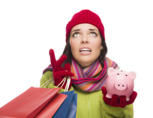Woman holding a piggy bank and shopping bags