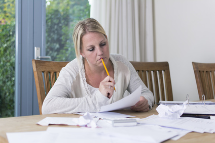Woman at dining room table looking at financial records