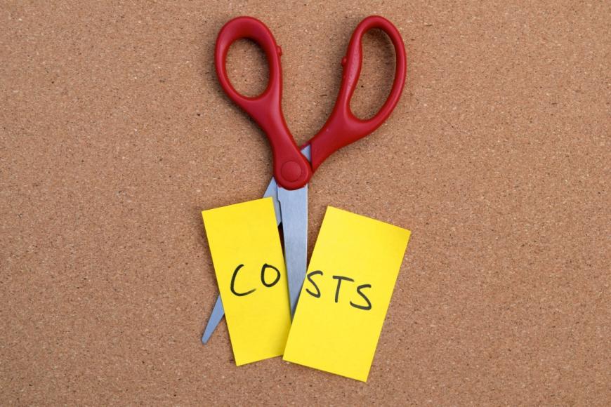 Scissors cutting a post it note that says "Costs"