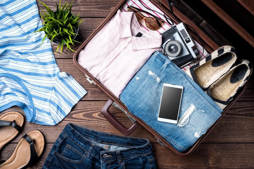 suitcase with clothes, sandals, phone and shoes