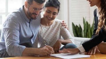 Biracial couple signing financial documents