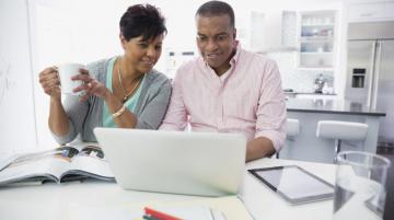 Middle-ages African American couple working at laptop