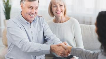 Older man with older woman, shaking hands with mental health care provider