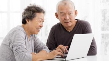 Couple of Asian descent looking at laptop screen