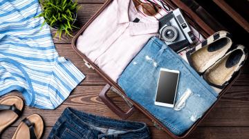 suitcase with clothes, sandals, phone and shoes