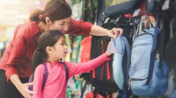 Mom and daughter buying backpack