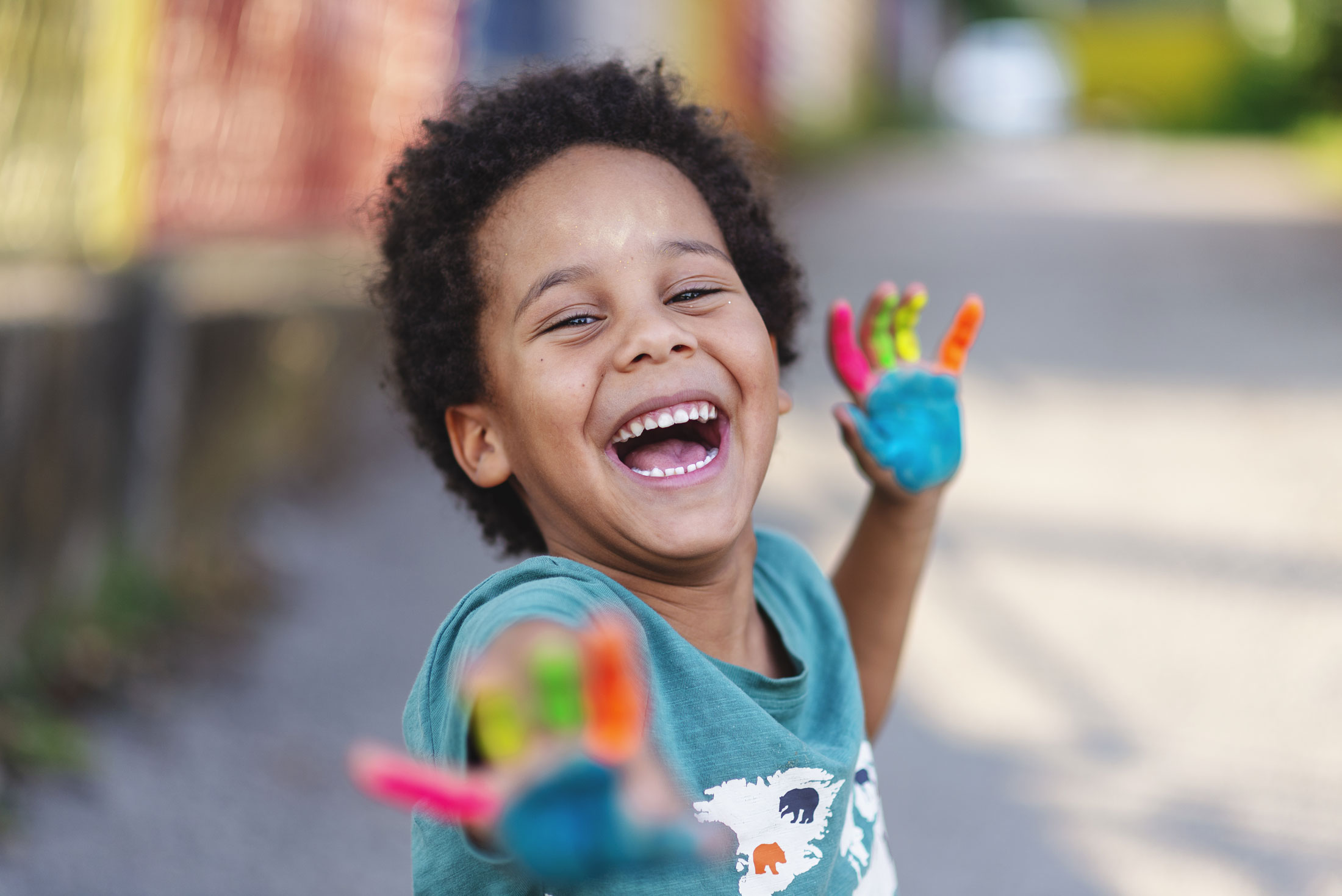 Child smiling with paint on their hands