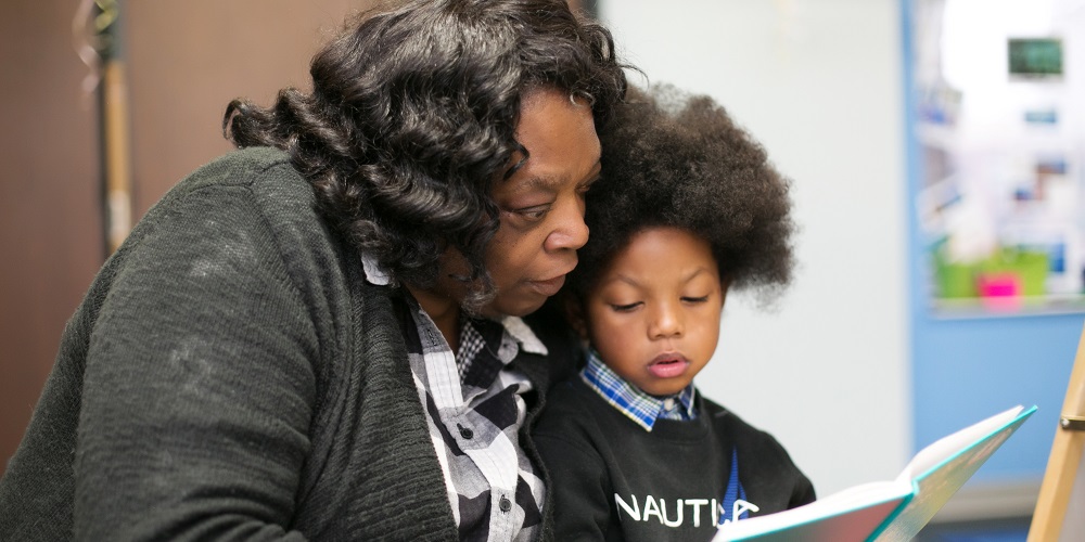 Foster Grandparent Volunteer reading to a child