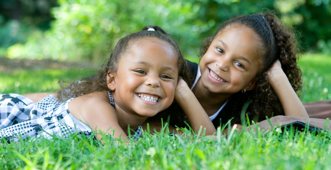 two girls sitting on grass