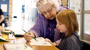 Foster Grandparents helping a child with their homework